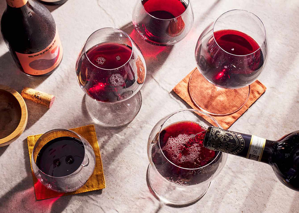 A variety of red wines in glasses shown from a bird's eye perspective.