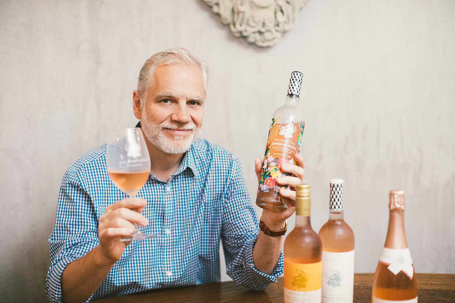 The owner of Wolffer Estate holding a glass of Summer in a Bottle.