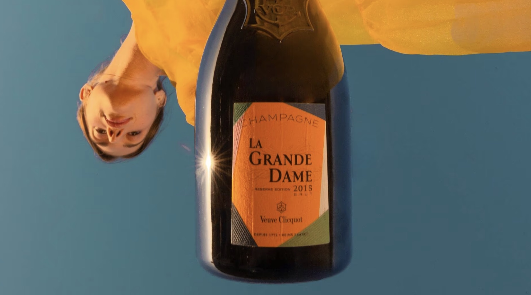 Image of La Grande Dame bottle with a woman upside down.