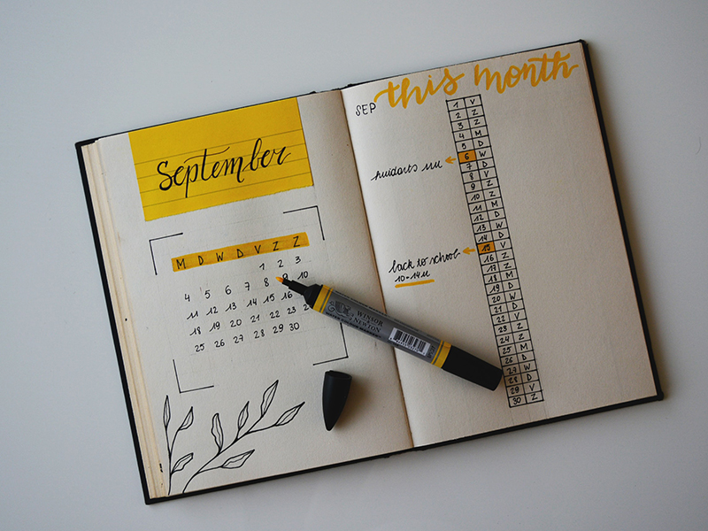 Notebook with a highlighted calendar and a highlighter